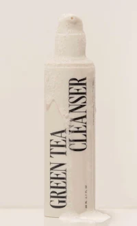 a bottle of green tea cleanser on a white surface